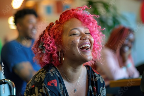 A woman with pink hair laughing in a restaurant setting