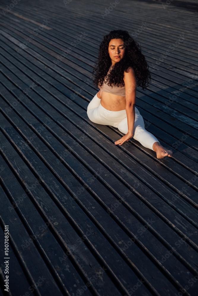 Athletic woman doing gymnastics yoga asana on wooden floor Athletic woman doing gymnastics yoga asana on wooden floor