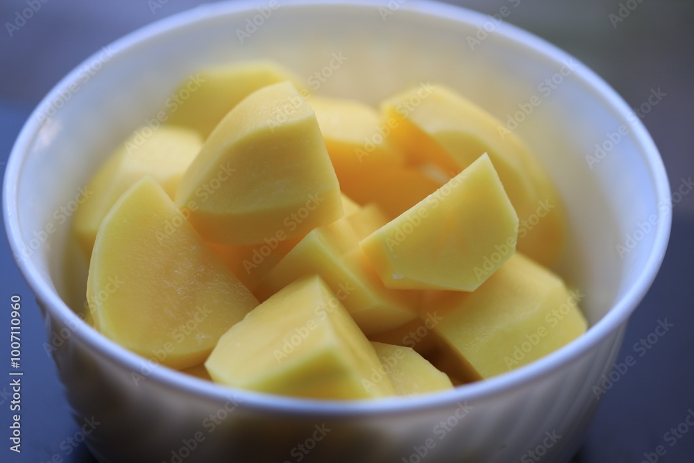 peeled potato pieces in a white plate. peeled potato pieces in a white plate.