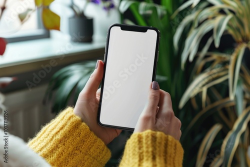 A woman in a yellow sweater holds a phone, possibly waiting for a call or checking the screen photo