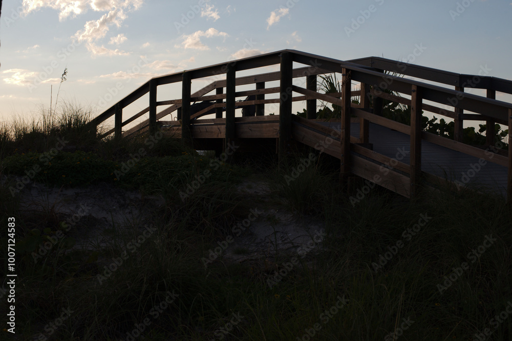 Wooden Beach Access Bridge on Sunny Day Blue sky white clouds towards at St. Pete Beach, FL towards the Gulf of Mexico. View over sand and sea oats. Near sunset late in the afternoon. Bright clouds
Wooden Beach Access Bridge on Sunny Day Blue sky white clouds towards at St. Pete Beach, FL towards the Gulf of Mexico. View over sand and sea oats. Near sunset late in the afternoon. Bright clouds