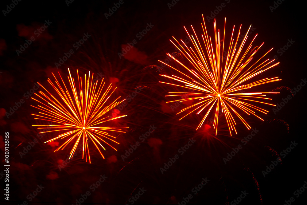 Fototapeta premium Multicolored pink gold bright sparks of fireworks on the black sky.