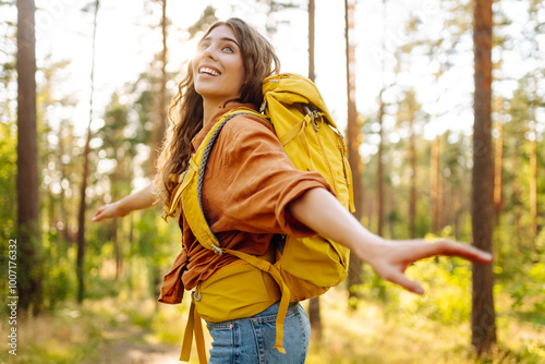 Young woman went on a hike in the forest feeling free and full of energy. Autumn landscape.