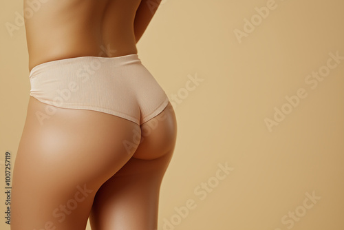 Perfect female curves from behind, soft skin body part against beige background with copy space. Self love and confidence concept.