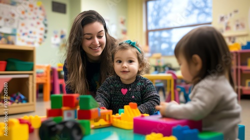 A young girl plays with colorful blocks while a smiling woman watches over her.