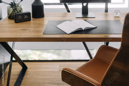 Photography Modern workspace setup with an open notebook on a wooden desk in a bright office