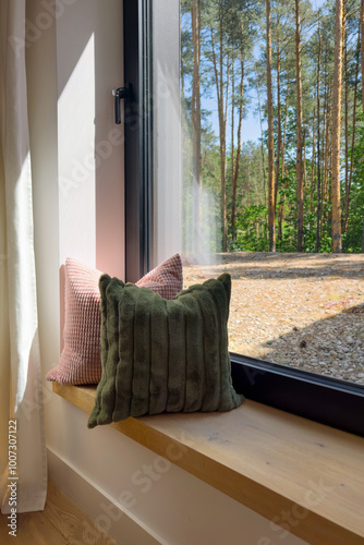 Cozy corner with decorative pillows beside a sunny window at home