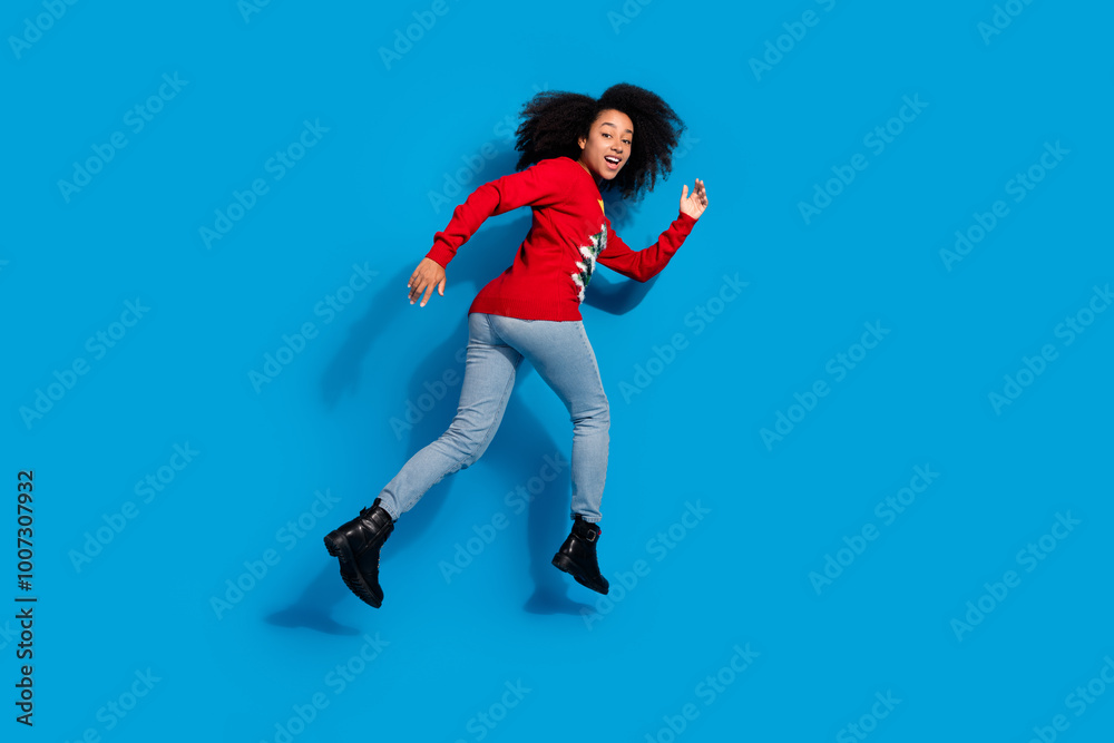 Photo of cheerful funny woman wear red stylish clothes go fast hurry christmas sale offer isolated on blue color background Photo of cheerful funny woman wear red stylish clothes go fast hurry christmas sale offer isolated on blue color background