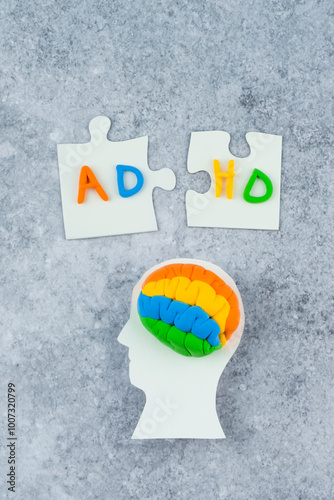 Head silhouette surrounded by puzzle pieces labeled ADHD, emphasizing awareness and understanding of this condition. Mental disorder concept photo