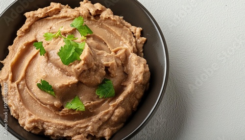 Refried beans - frijoles refritos -or rehashed or warmed over beans is a dish of cooked and mashed beans that is a traditional staple of Mexican and Tex Mex cuisine. Isolated on white with copy space photo