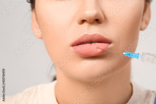 Young woman receiving lip i...