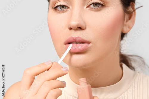 Young woman applying lipsti...