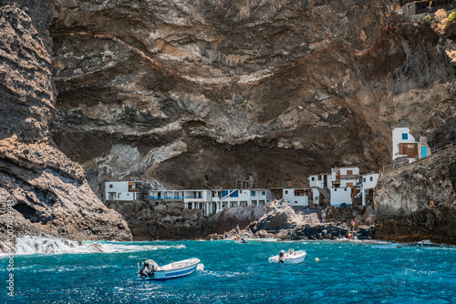 Coastal village next to cliffs with boats in turquoise waters. Porís de Candelaria on the island of La Palma