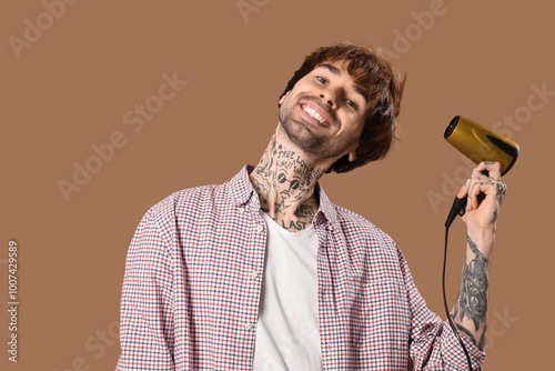 Young tattooed barber dryin...