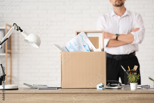 Fired young man with box of...