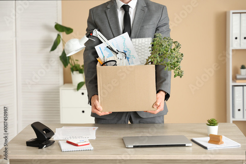 Fired young man holding box...