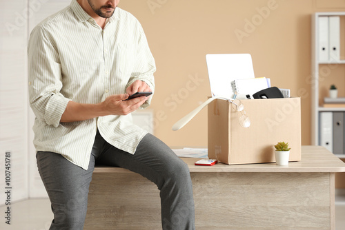 Fired young man with mobile...