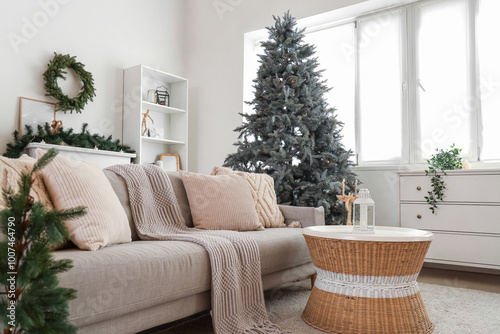 Beautiful Christmas tree, table and sofa in interior of living room