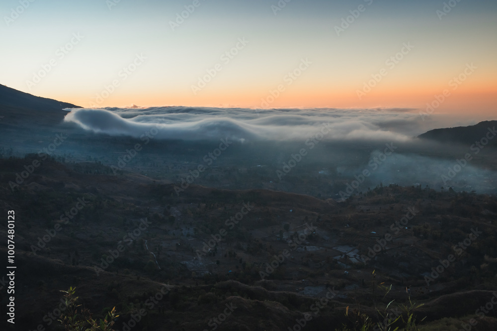 Obraz premium Clouds in a mountain valley at sunset.