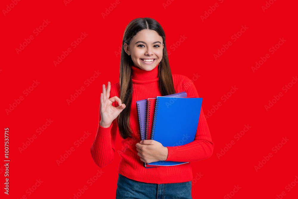 Knowledge through study. Teen girl studying with workbook. Back to school. Knowledge and education. Teen girl student isolated on red. September 1. High school education. Ok