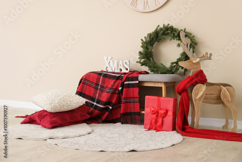 Christmas wreath on bench and wooden reindeer in room