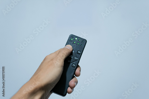 Wallpaper Mural a hand holding a black remote Torontodigital.ca