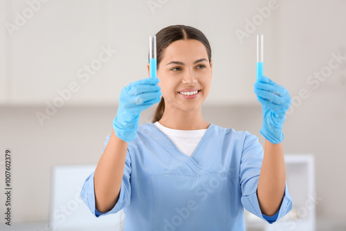 Happy female young scientist with test tubes of water samples in research laboratory