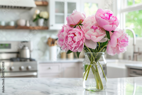 Beautiful Peonies in Vase on Granite Countertop Island in Stylish White Minimal Kitchen with Wooden Shelves in New House