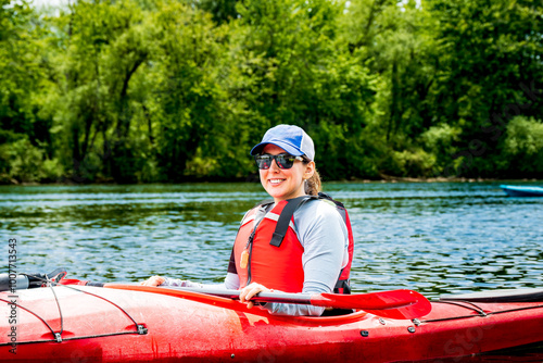 happy young woman in red sea kayak paddling on the toronto islands room for text photo