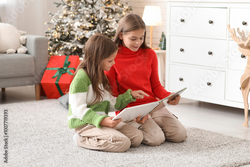 Two young girls reading boo...