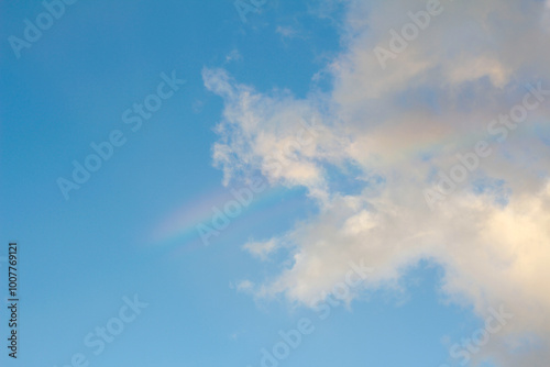 Rainbow and clouds on sky at sunset