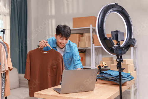 Fotografie Asian vlogger man influencer review or sell product on live streaming, work at h