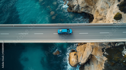 Top down view of an electric car driving on a road surrounded by the sea. Aerial photography photo