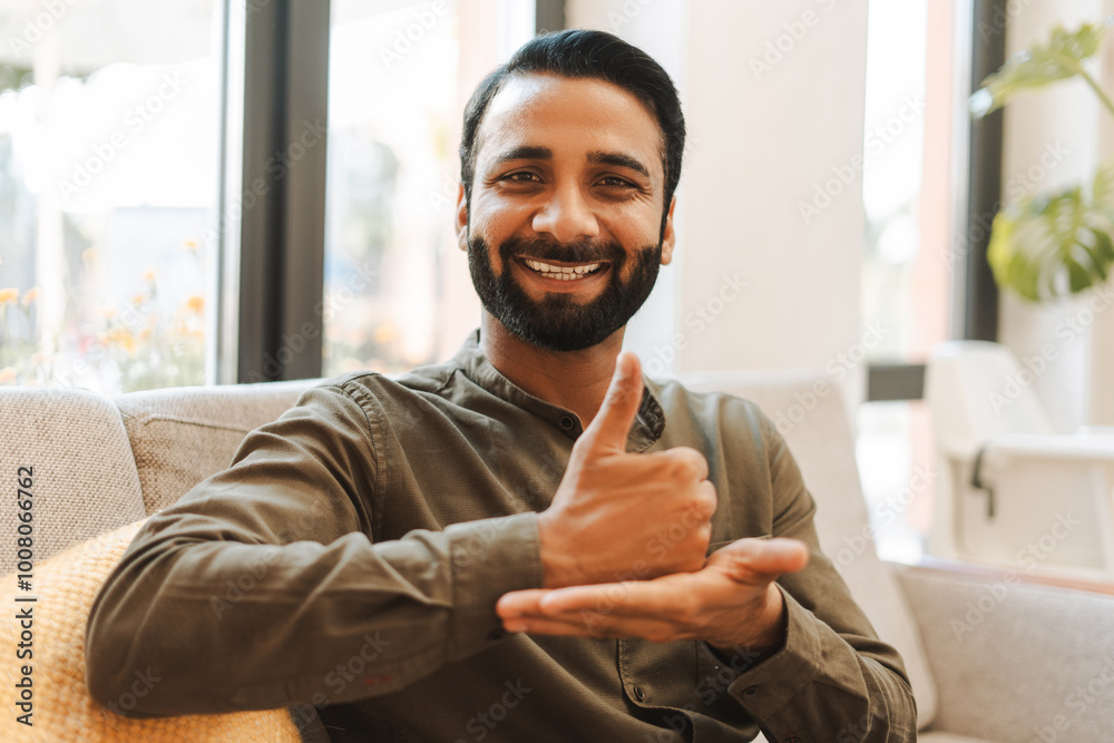Portrait of happy Indian man speaking with sign language, showing thump up Portrait of happy Indian man speaking with sign language, showing thump up