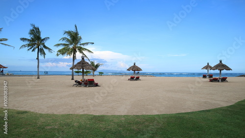 Stunning view on Nusa Dua Bali. Tranquil beach with soft sand, blue sky clear, sea and lush palm trees against the backdrop of an endless horizon.