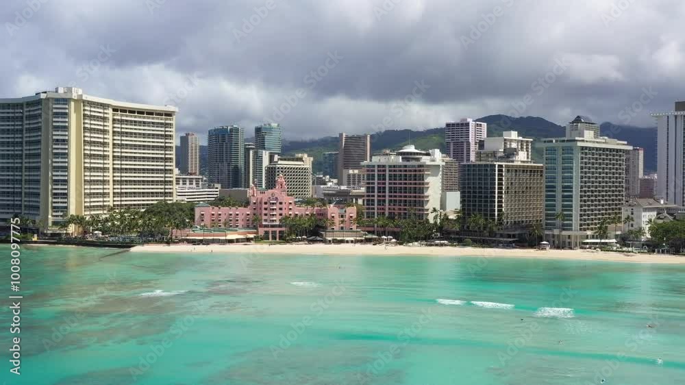 Drone capturing modern city buildings by turquoise sea during daytime in Egland, UK, scenic water views under cloudy sky creating blend of cityscape and natural beauty Drone capturing modern city buildings by turquoise sea during daytime in Egland, UK, scenic water views under cloudy sky creating blend of cityscape and natural beauty