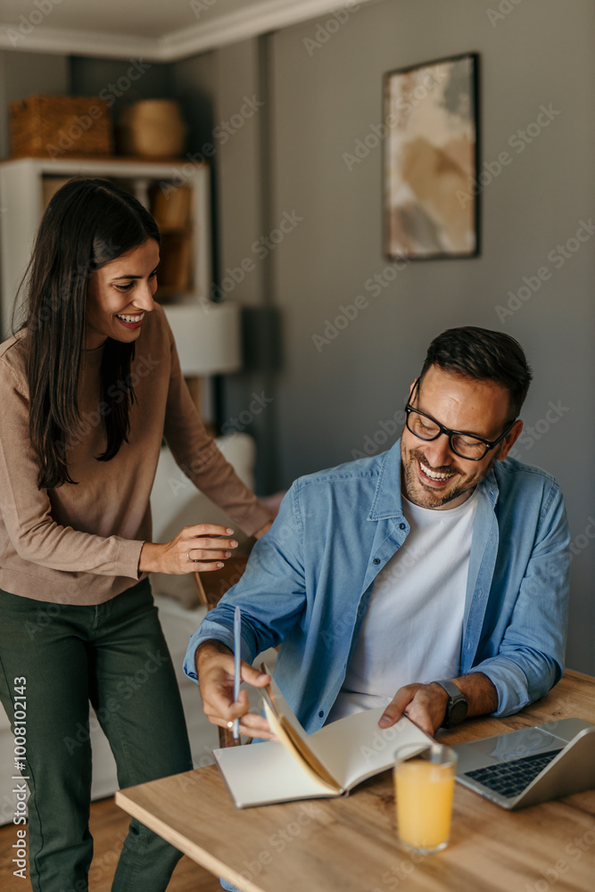 Adult man work from home while his wife hug and stand with him Adult man work from home while his wife hug and stand with him