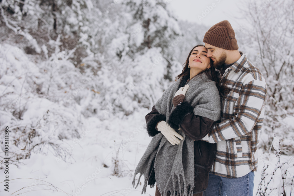 Portrait of a young happy and loving couple having fun in a snowy forest Portrait of a young happy and loving couple having fun in a snowy forest
