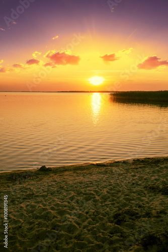 Sunset in the lake. Beach at sunset on the Shatsky Lakes, Ukraine. Vertical image photo