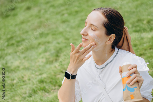 Young Woman Is Applying Sunscreen To Her Face Outdoors, Ensuring Protection From The Sun's Rays. Cancer Prevention Concept