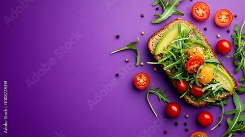 An avocado toast styled on a purple surface, garnished with arugula and cherry tomatoes. Perfect for use in ads or menus with space left for text.