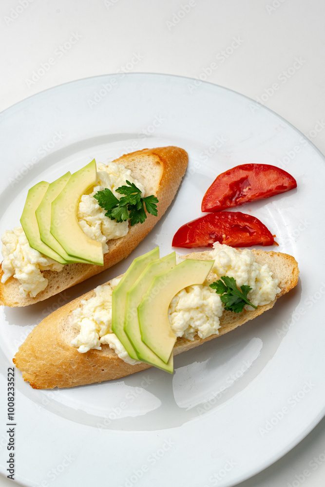 Fresh avocado and cheese spread on toasted bread garnished with cilantro and tomato Fresh avocado and cheese spread on toasted bread garnished with cilantro and tomato