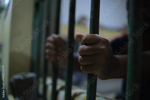 Hands of the prisoner on a steel lattice close up