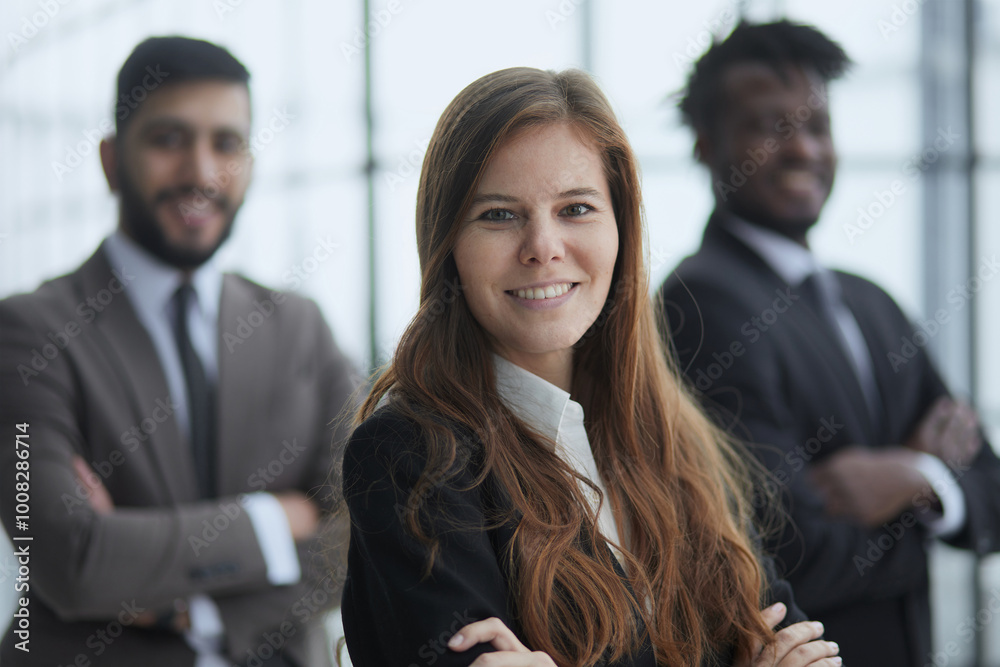 Three multiethnic workers in formal suits standing for camera indoors and smiling. Three multiethnic workers in formal suits standing for camera indoors and smiling.