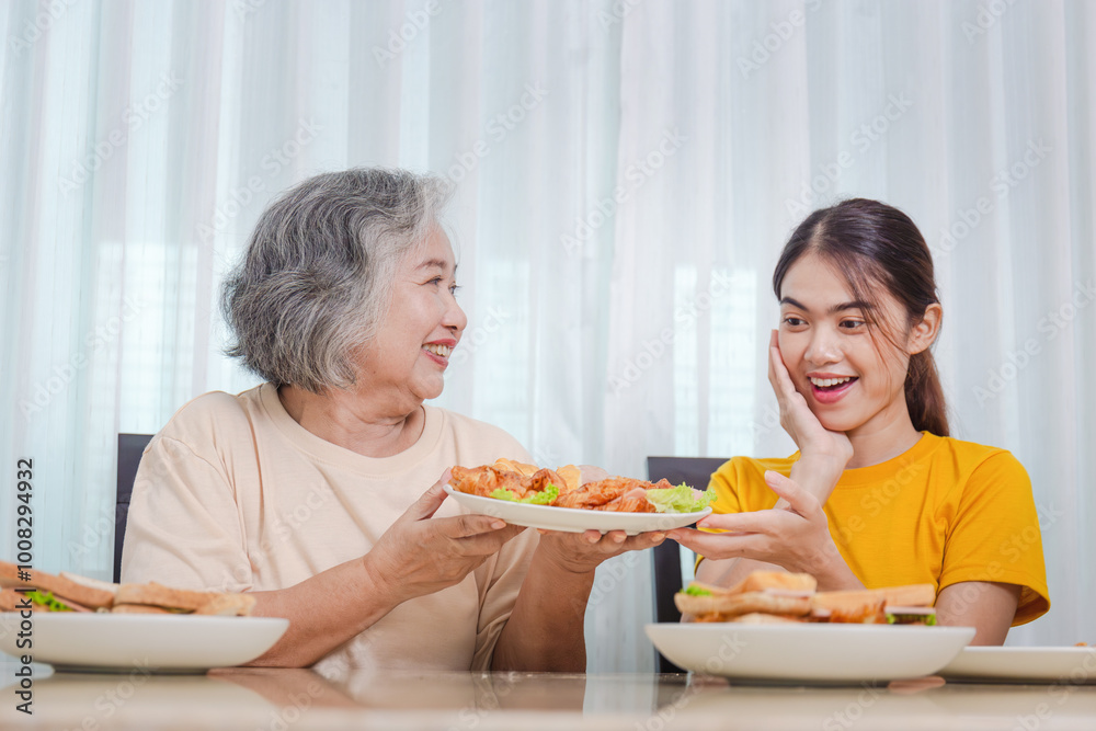 Mother and adult daughter eating meal together, Senior woman and daughter having breakfast in morning together Mother and adult daughter eating meal together, Senior woman and daughter having breakfast in morning together