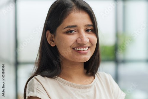 portrait of a smiling business woman with her arms crossed against the backdrop of the office