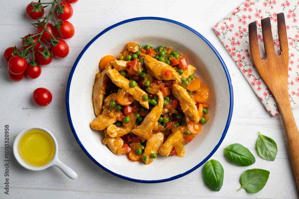 Sautéed chicken strips with vegetables and tomato sauce. Top view table with decoration. Sautéed chicken strips with vegetables and tomato sauce. Top view table with decoration.