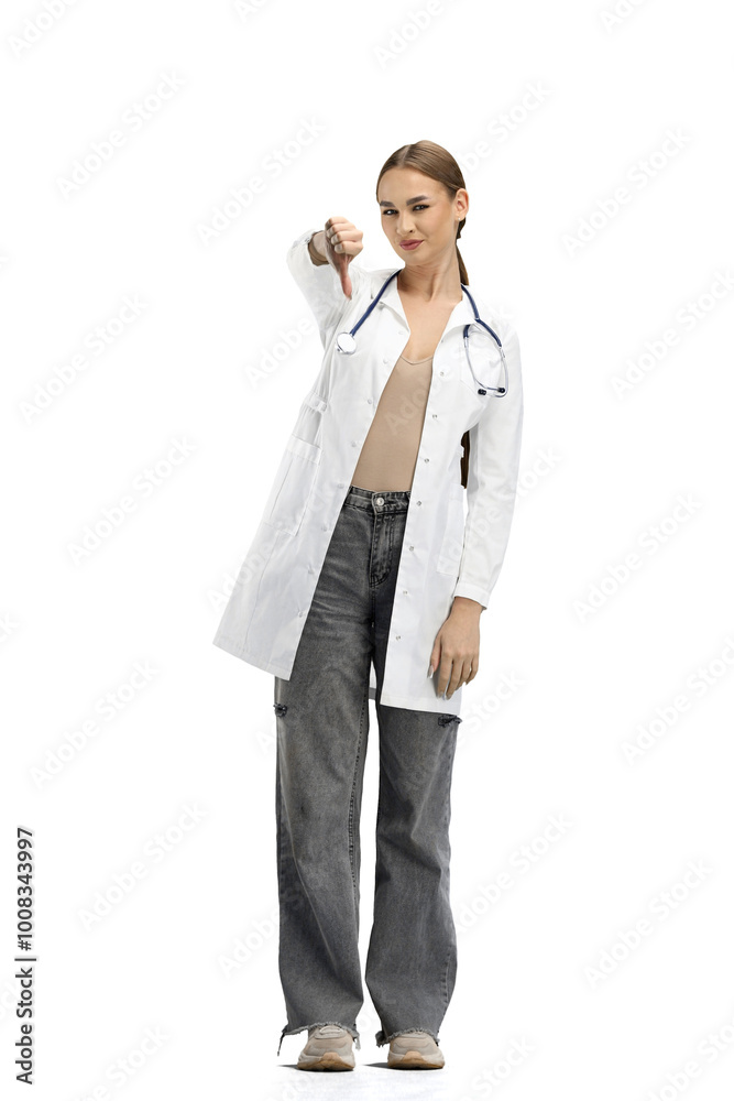 A female doctor, full-length, on a white background, shows her finger down A female doctor, full-length, on a white background, shows her finger down