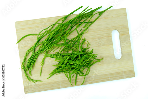 Heap of fresh Senegalia pennata (Acacia pennata) leaves or Cha-om in Thai on wooden cutting board, isolated on white background with clipping path top view flat lay, focus stacking photo