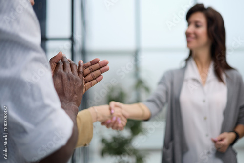 Two Businesswomen Shaking Hands In Modern Office